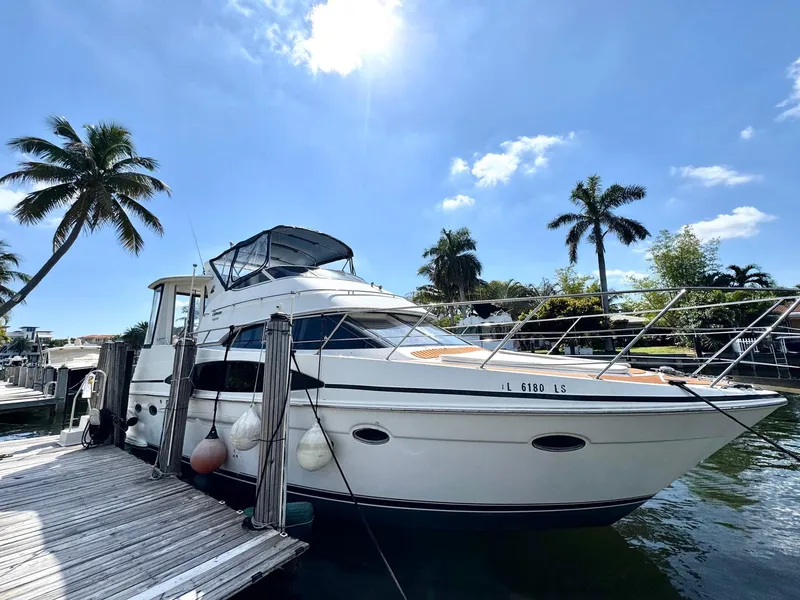 Slide: The Image of 2001 Carver 396 Motor Yacht docked under a clear blue sky with palm trees. - 2