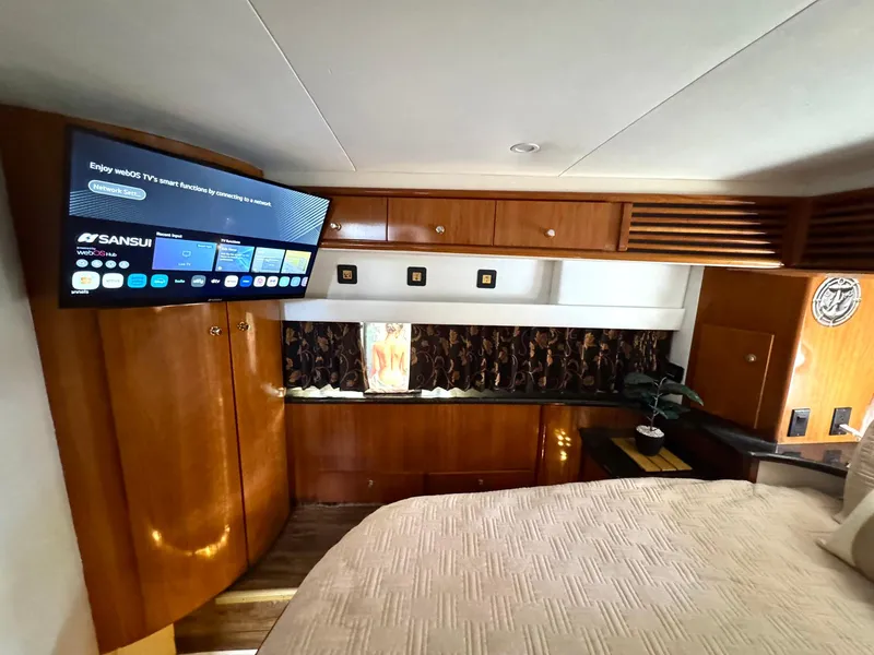 Slide: The Image of Interior of 2001 Carver 396 Motor Yacht with wood cabinetry and mounted TV. - 21