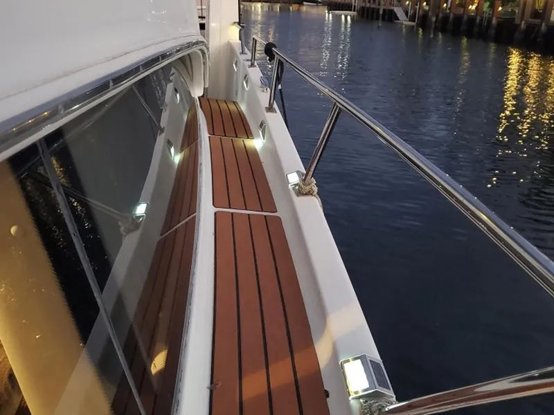 Slide: The Image of Carver 396 Motor Yacht 2001, illuminated deck, wooden flooring, docked at night. - 32