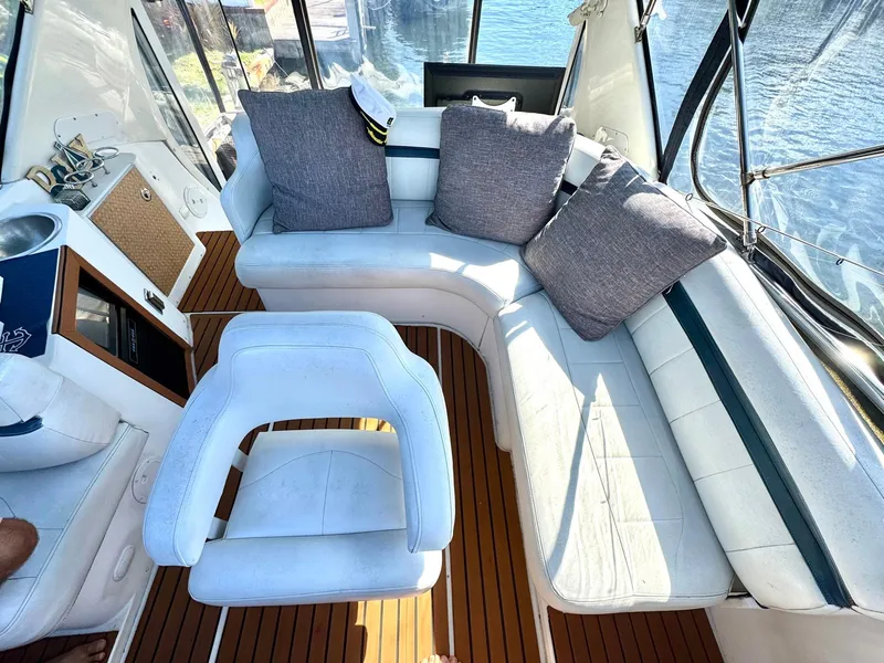 Slide: The Image of 2001 Carver 396 Motor Yacht interior with white seating and wooden flooring. - 6