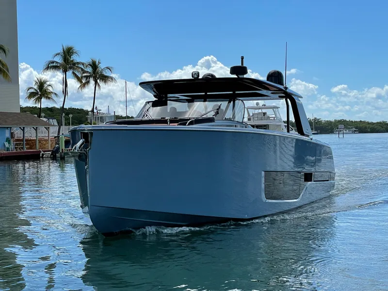 Slide: The Image of 2023 Cranchi A46 yacht cruising on a sunny day with palm trees in the background. - 2