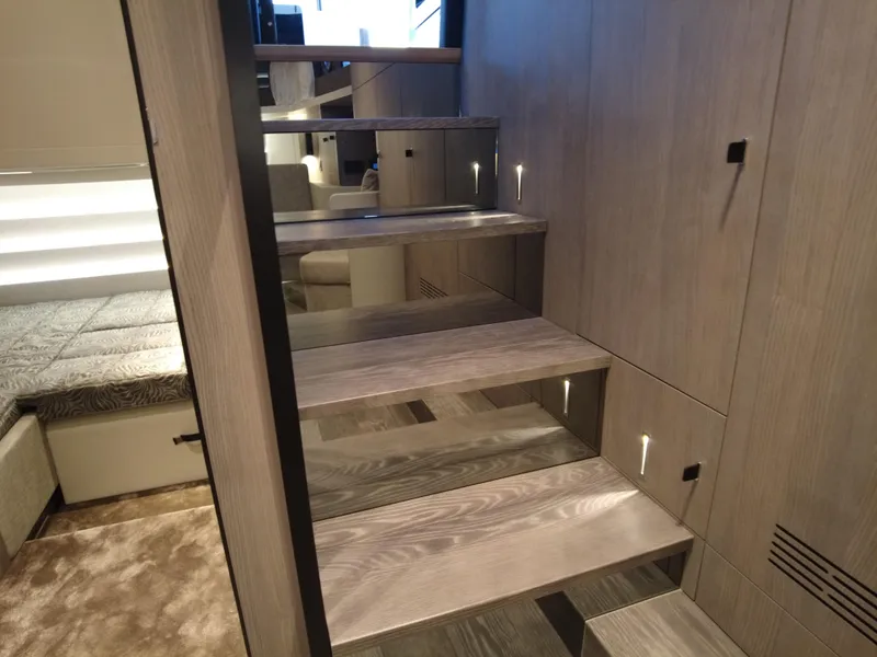 Slide: The Image of Modern interior stairs on 2023 Cranchi A46 yacht, featuring sleek wooden design and ambient lighting. - 22