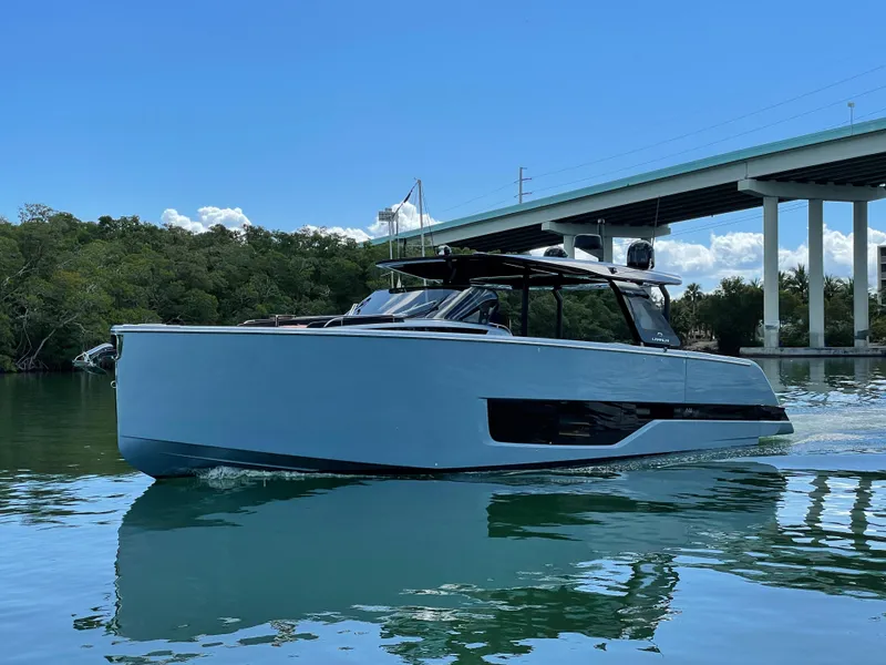 Slide: The Image of 2023 Cranchi A46 yacht cruising on calm water under a bridge. - 5
