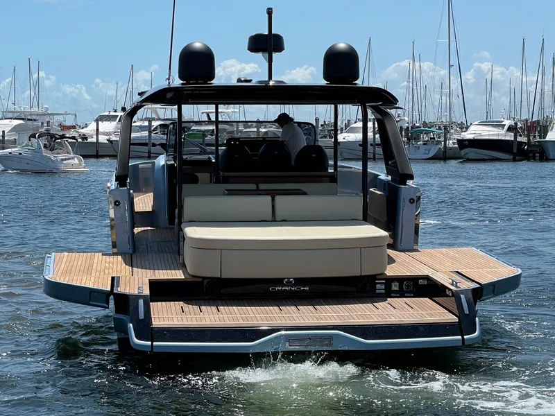 Slide: The Image of 2023 Cranchi A46 yacht docked in marina, showcasing spacious deck and modern design. - 8