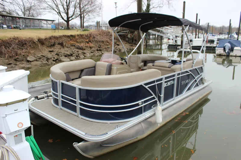 The Image of 2023 Sylvan Mirage 820 LZ pontoon boat with change room, docked in a marina. - 0