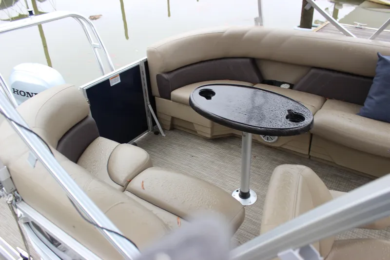 Slide: The Image of 2023 Sylvan Mirage 820 LZ boat interior with beige seating and a round table. - 14