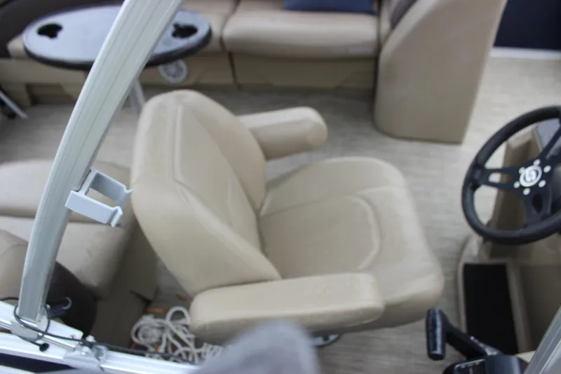 Slide: The Image of 2023 Sylvan Mirage 820 LZ interior with beige seating and steering wheel. - 15