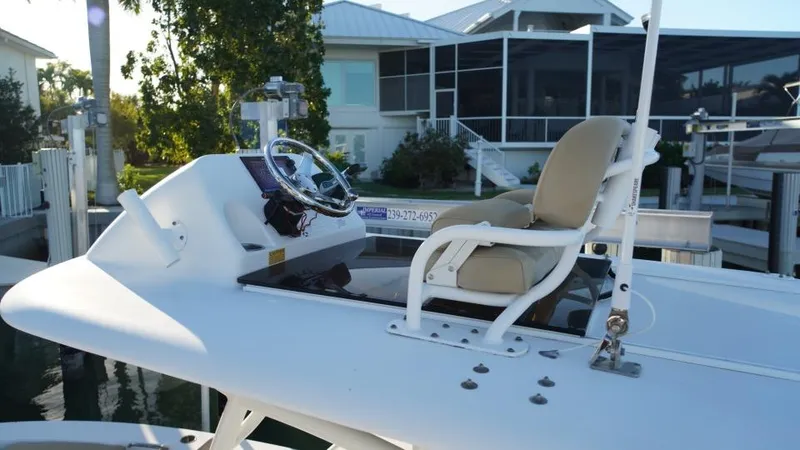 Slide: The Image of 2017 Sportsman Masters 267 Bay Boat with helm and seating, docked near waterfront home. - 14