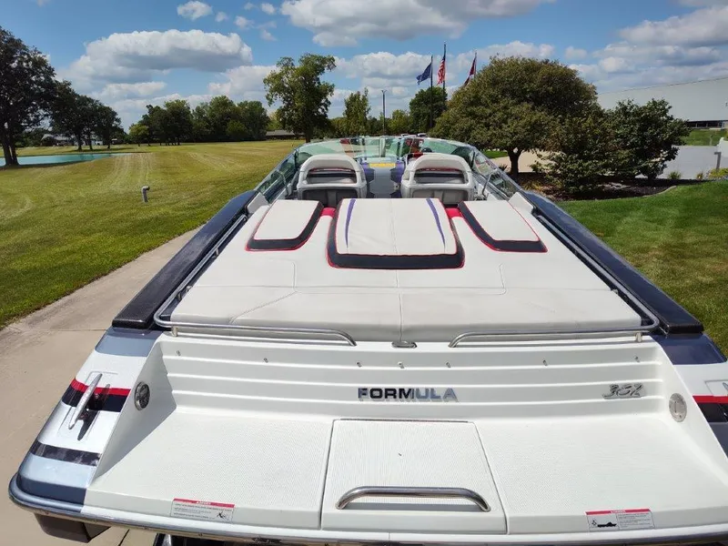 Slide: The Image of 2015 Formula 382 FASTech boat, rear view, parked on a sunny day with lush greenery. - 23