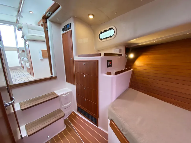 Slide: The Image of Interior of 2010 Pearson 38 True North yacht, featuring wooden cabinetry and cozy sleeping area. - 15