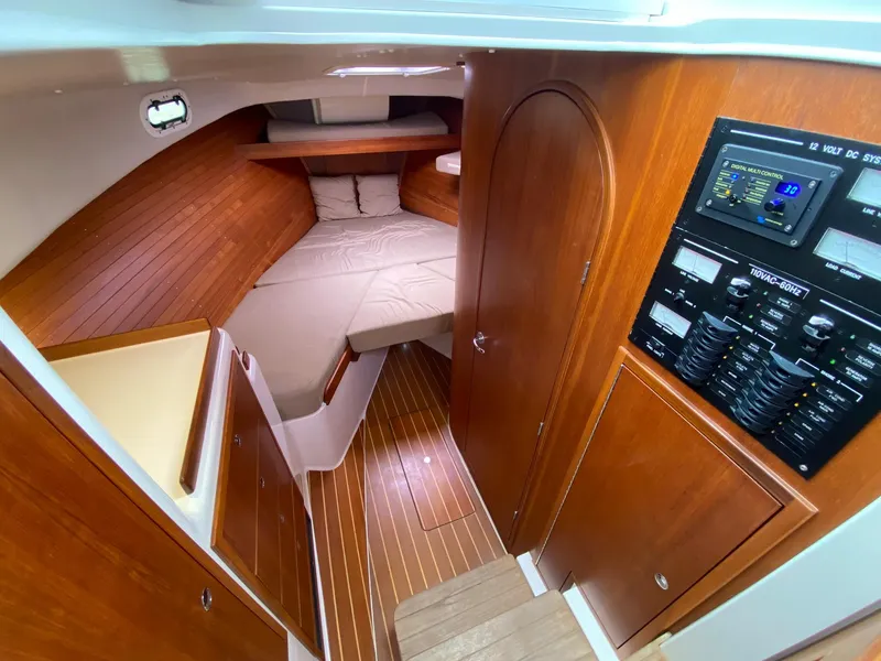 Slide: The Image of Interior of 2010 Pearson 38 True North yacht with wood paneling and cozy sleeping area. - 16