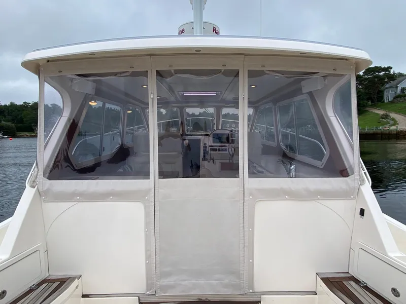 Slide: The Image of 2010 Pearson 38 True North boat with enclosed cockpit on calm water. - 2