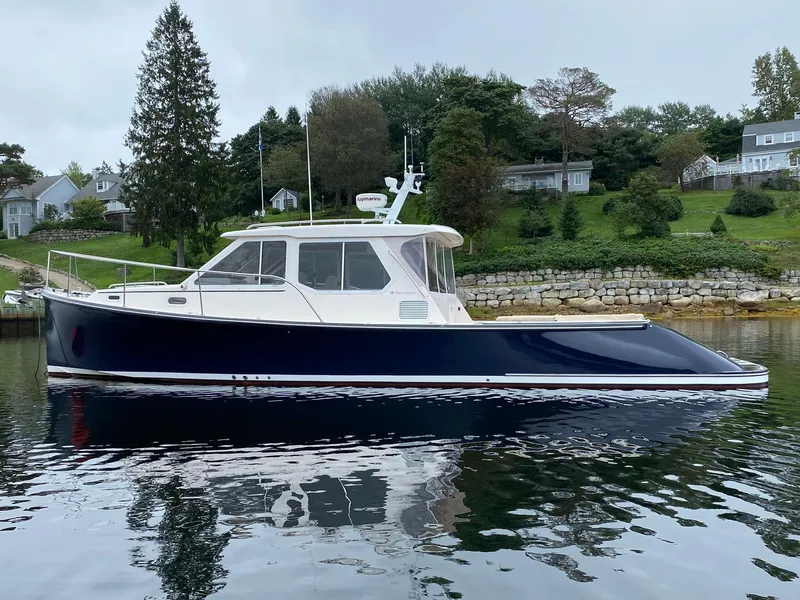 Slide: The Image of Pearson 38 True North 2010 boat on calm water, with scenic shoreline background. - 26
