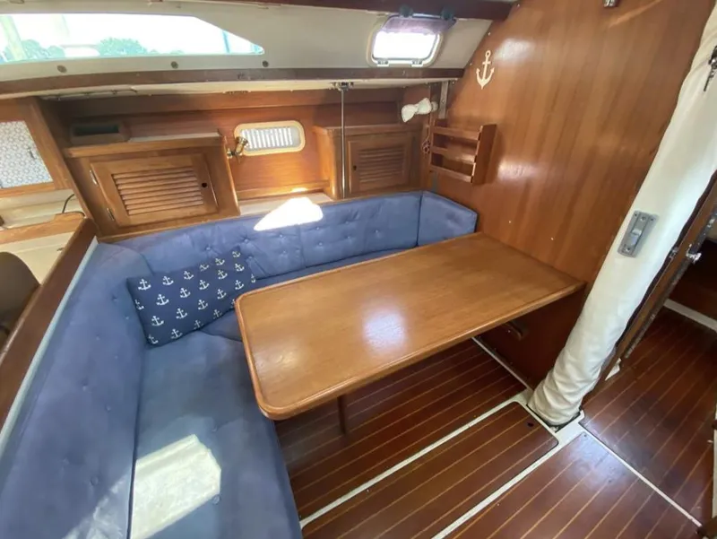 Slide: The Image of Interior of 1995 Catalina 36 MkII sailboat with wooden table and blue cushioned seating. - 23