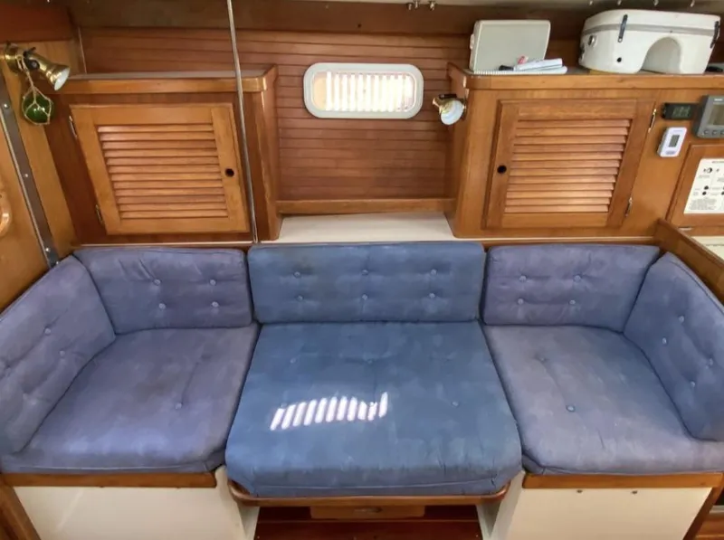 Slide: The Image of Interior of 1995 Catalina 36 MkII sailboat with blue cushioned seating and wooden cabinetry. - 25