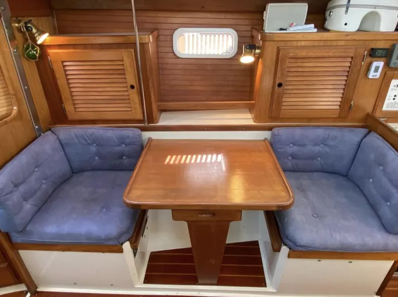 Slide: The Image of Interior of 1995 Catalina 36 MkII sailboat with wooden table and blue cushioned seating. - 26