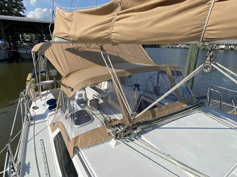 Slide: The Image of 1995 Catalina 36 MkII sailboat with tan canvas covers docked by the water. - 3
