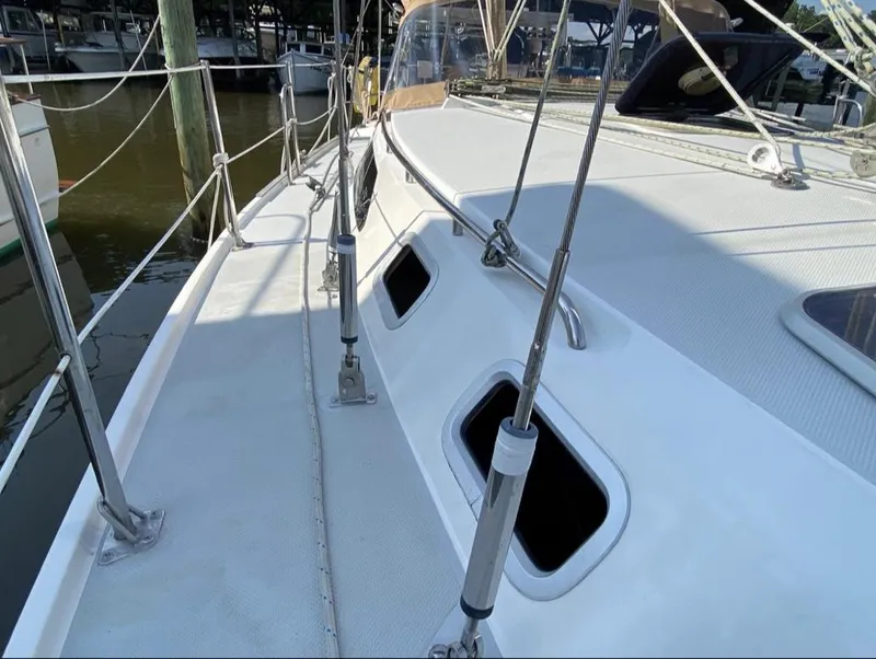 Slide: The Image of 1995 Catalina 36 MkII sailboat deck with railing and windows at a marina. - 4