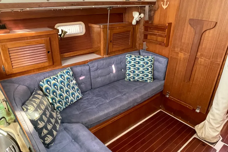 Slide: The Image of Interior of 1995 Catalina 36 MkII sailboat with blue cushioned seating and wooden cabinetry. - 46