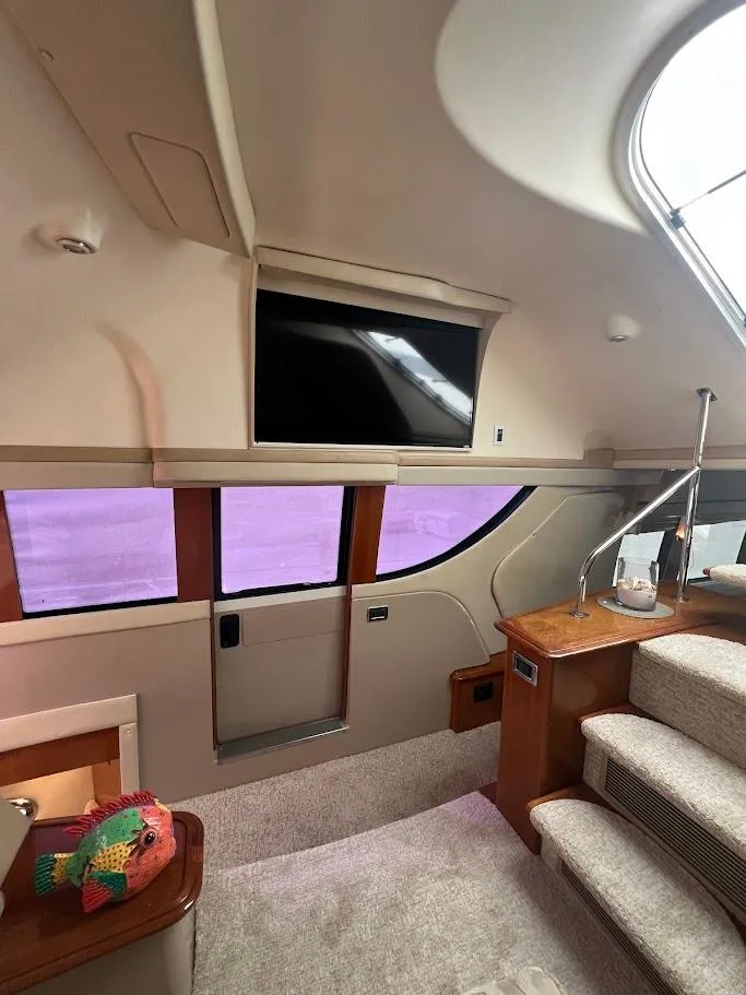 Slide: The Image of Interior of 2006 Carver Voyager Sky Lounge with TV and stairs, featuring modern design. - 13