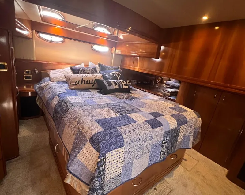 Slide: The Image of Luxurious bedroom in 2006 Carver Voyager Sky Lounge yacht with cozy bedding and wood paneling. - 18