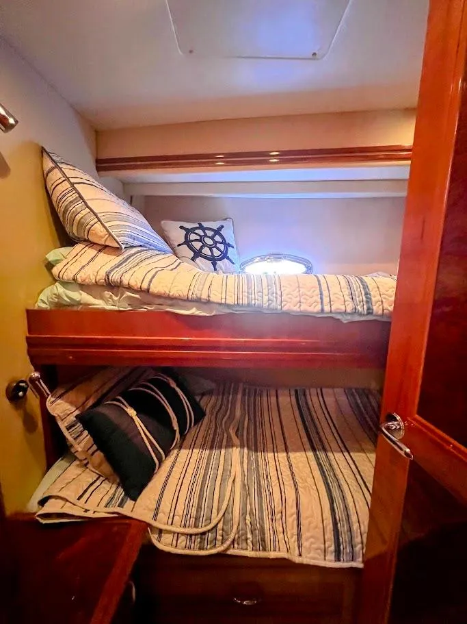 Slide: The Image of 2006 Carver Voyager Sky Lounge cabin with cozy bunk beds and nautical-themed decor. - 24
