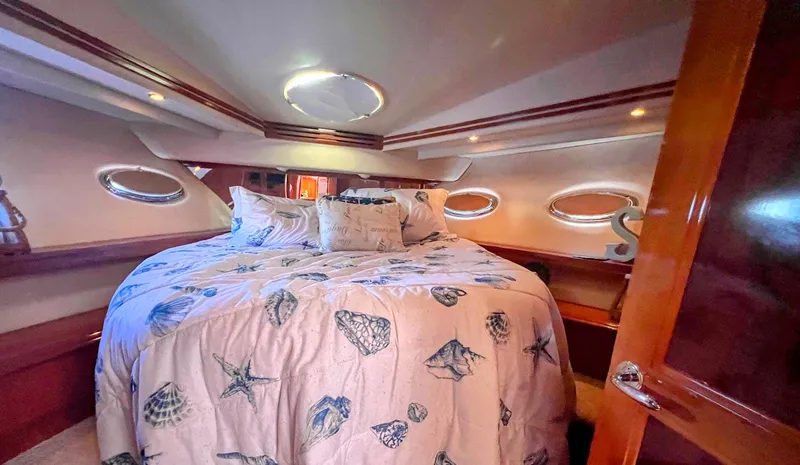 Slide: The Image of Luxurious bedroom in 2006 Carver Voyager Sky Lounge yacht with nautical-themed bedding. - 26