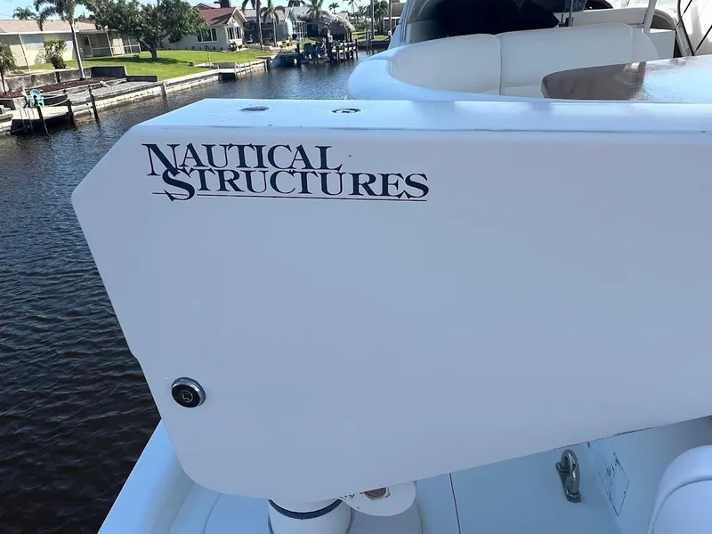 Slide: The Image of 2006 Carver Voyager boat with Nautical Structures branding, docked by a canal. - 29