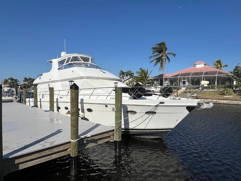 Slide: The Image of 2006 Carver Voyager Sky Lounge yacht docked by waterfront homes. - 3
