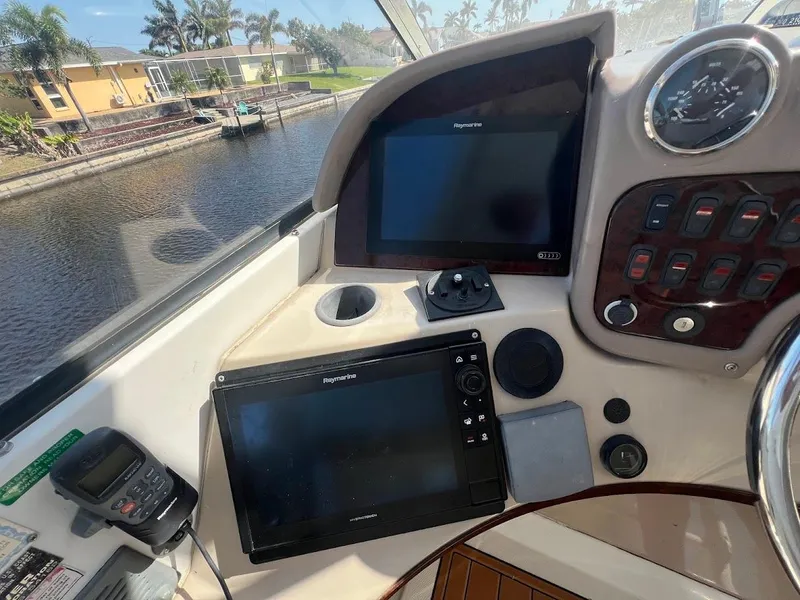 Slide: The Image of 2006 Carver Voyager helm with navigation screens and controls, docked by a canal. - 35
