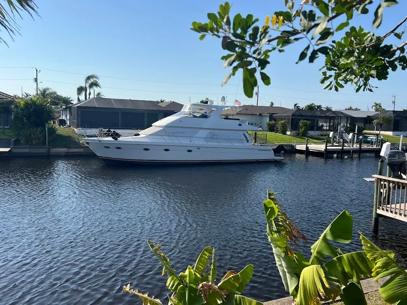 Slide: The Image of 2006 Carver Voyager Sky Lounge yacht docked in a serene canal setting. - 4