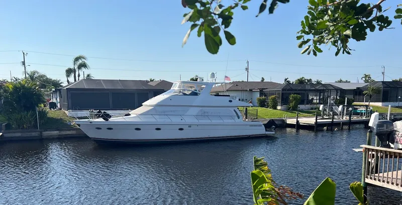 Slide: The Image of 2006 Carver Voyager Sky Lounge yacht docked in a serene residential canal. - 58