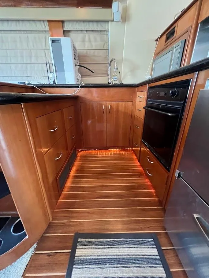 Slide: The Image of 2006 Carver Voyager Sky Lounge kitchen with wood cabinetry and modern appliances. - 9