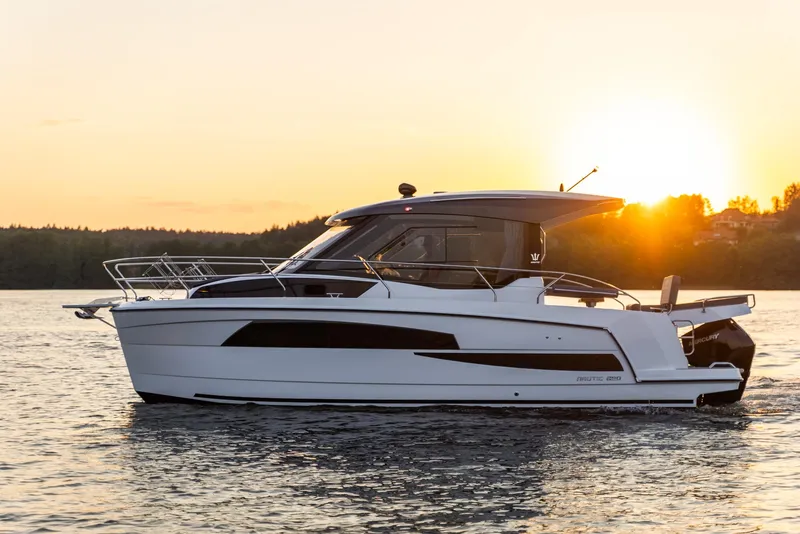 The Image of 2025 Nautic 880 boat cruising at sunset on a serene lake. - 0
