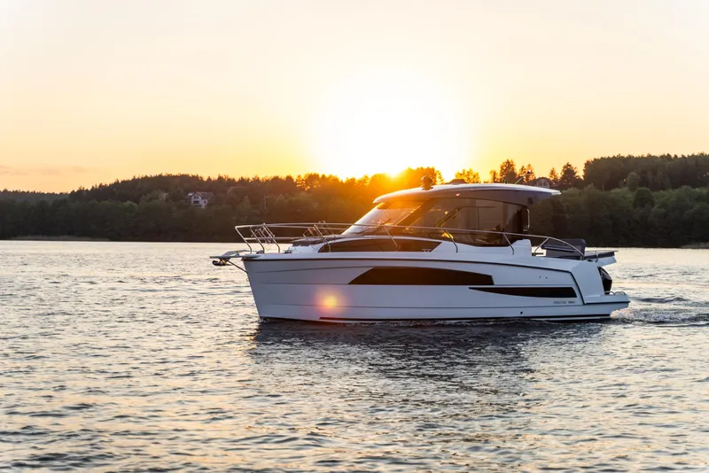 Slide: The Image of 2025 Nautic 880 boat cruising at sunset on a serene lake. - 1