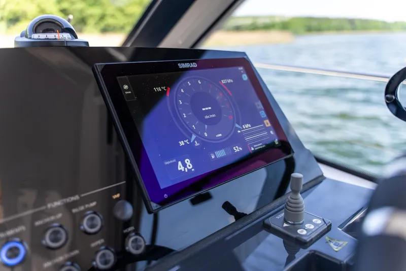 Slide: The Image of Control panel of 2025 Nautic 880 boat with digital display and joystick on a sunny day. - 13