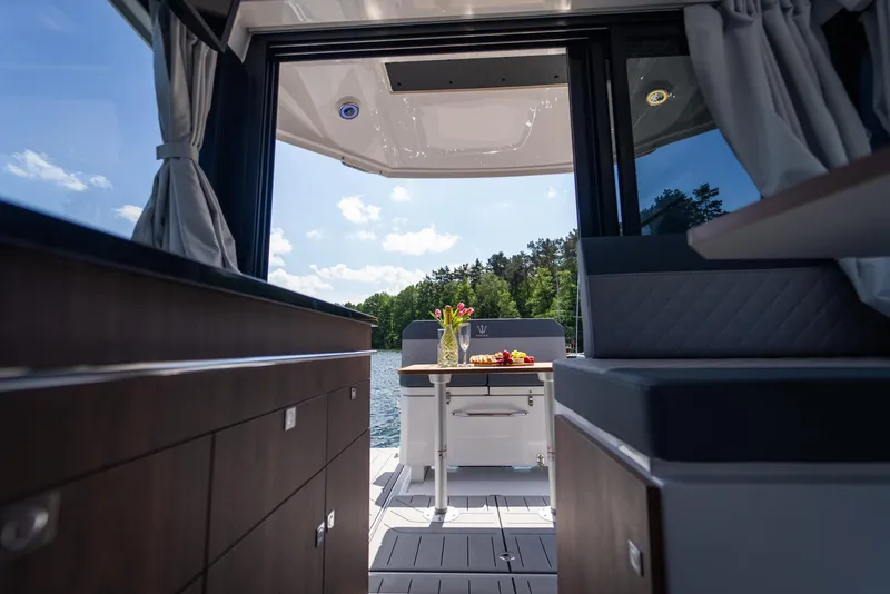 Slide: The Image of Luxurious interior of 2025 Nautic 880 yacht with lake view and elegant dining setup. - 14