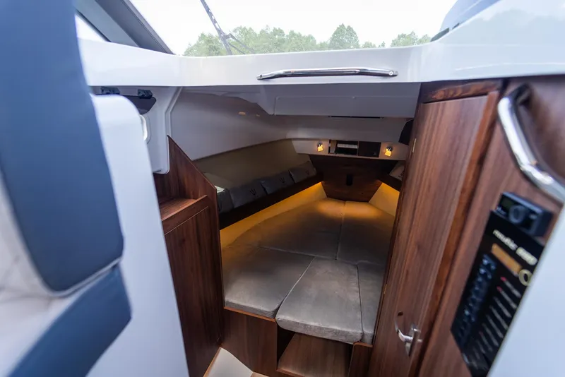 Slide: The Image of Interior of 2025 Nautic 880 boat, featuring cozy cabin with wood accents and ambient lighting. - 18