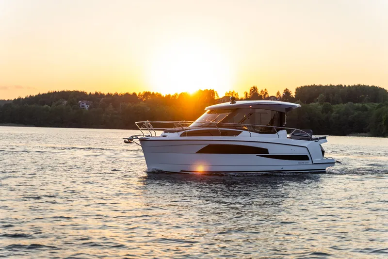 Slide: The Image of 2025 Nautic 880 boat cruising on a serene lake at sunset. - 24