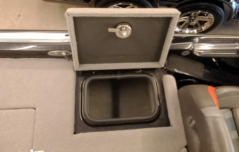 Slide: The Image of 2020 Bass Cat Puma FTD storage compartment with open lid and lock mechanism. - 28