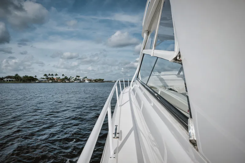 Slide: The Image of Intrepid 475 Sport Yacht 2018 cruising on open water under a cloudy sky. - 17