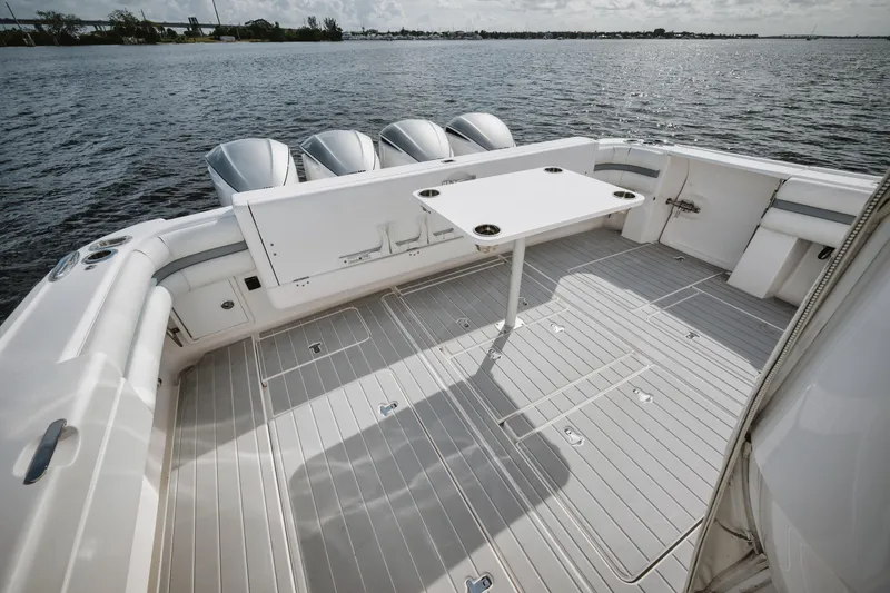 Slide: The Image of 2018 Intrepid 475 Sport Yacht deck with table, overlooking calm waters. - 28