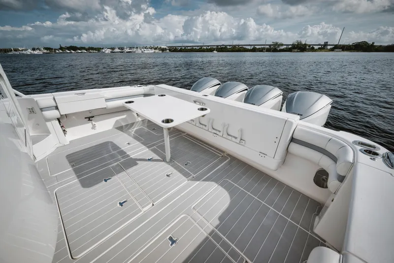 Slide: The Image of 2018 Intrepid 475 Sport Yacht deck with seating and table, overlooking calm waters. - 29