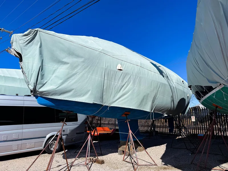 Slide: The Image of 2005 Jeanneau 40.3 sailboat covered and stored on stands in a boatyard. - 10