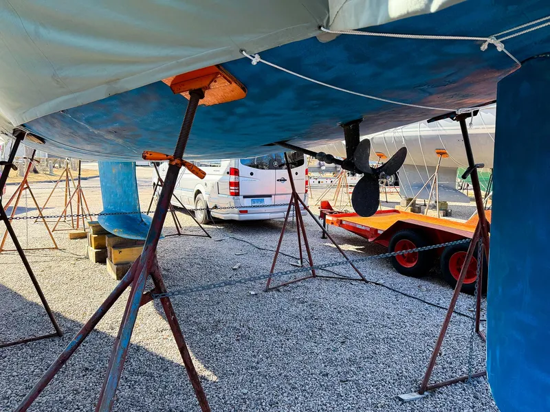 Slide: The Image of Jeanneau 40.3 sailboat from 2005 on stands, with visible propeller and nearby vehicles. - 12