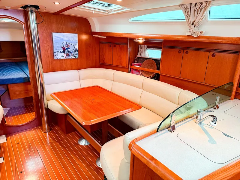 Slide: The Image of Luxurious interior of a 2005 Jeanneau 40.3 sailboat with elegant wood finish and cozy seating. - 15
