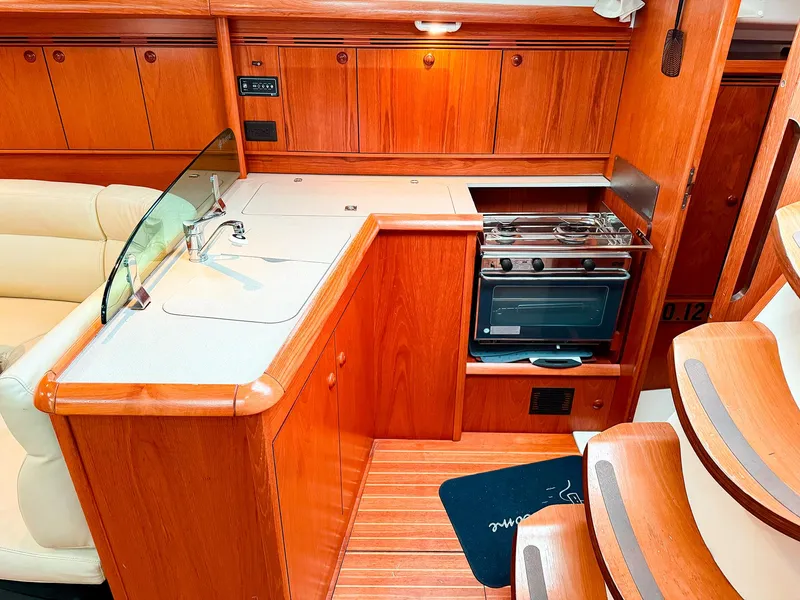 Slide: The Image of Interior of 2005 Jeanneau 40.3 yacht with wooden cabinetry and compact kitchen area. - 18