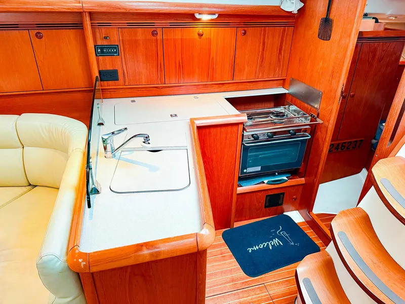 Slide: The Image of Interior of 2005 Jeanneau 40.3 yacht kitchen with stove, sink, and wooden cabinetry. - 23