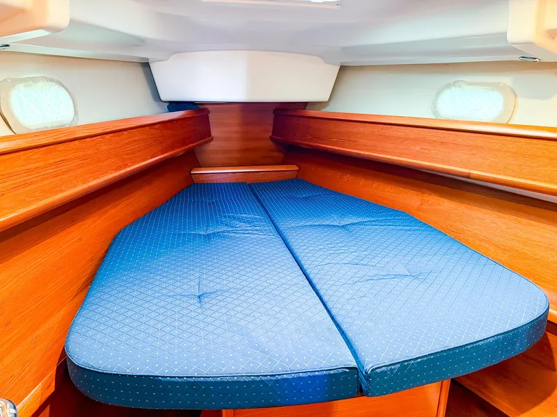 Slide: The Image of Cozy cabin interior of 2005 Jeanneau 40.3 sailboat with blue mattress and wooden finish. - 28