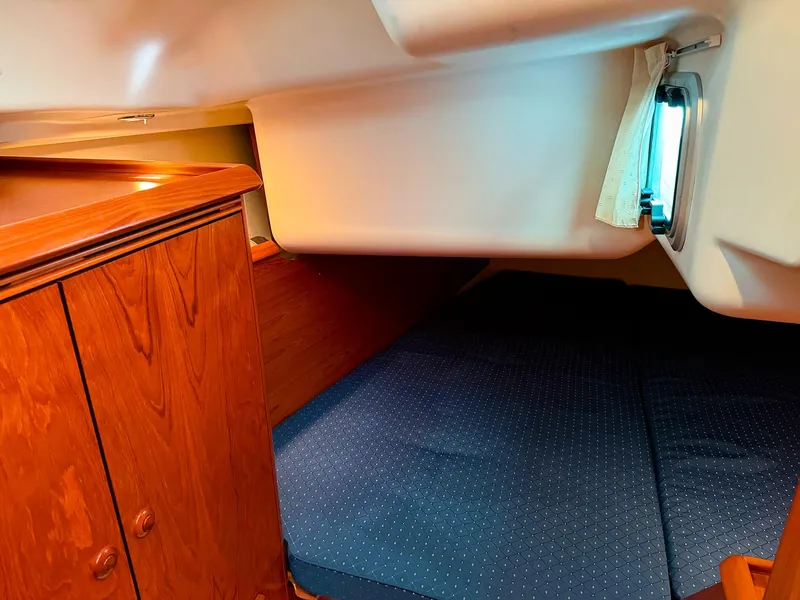 Slide: The Image of Cozy cabin interior of 2005 Jeanneau 40.3 sailboat with wooden cabinetry and blue bedding. - 29